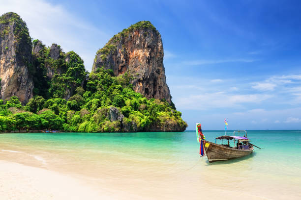 Thai traditional wooden longtail boat and beautiful sand Railay Beach in Krabi province. Ao Nang, Thailand.