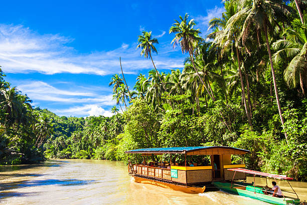 Exotic cruise boat with tourists on a jungle river Loboc, Bohol